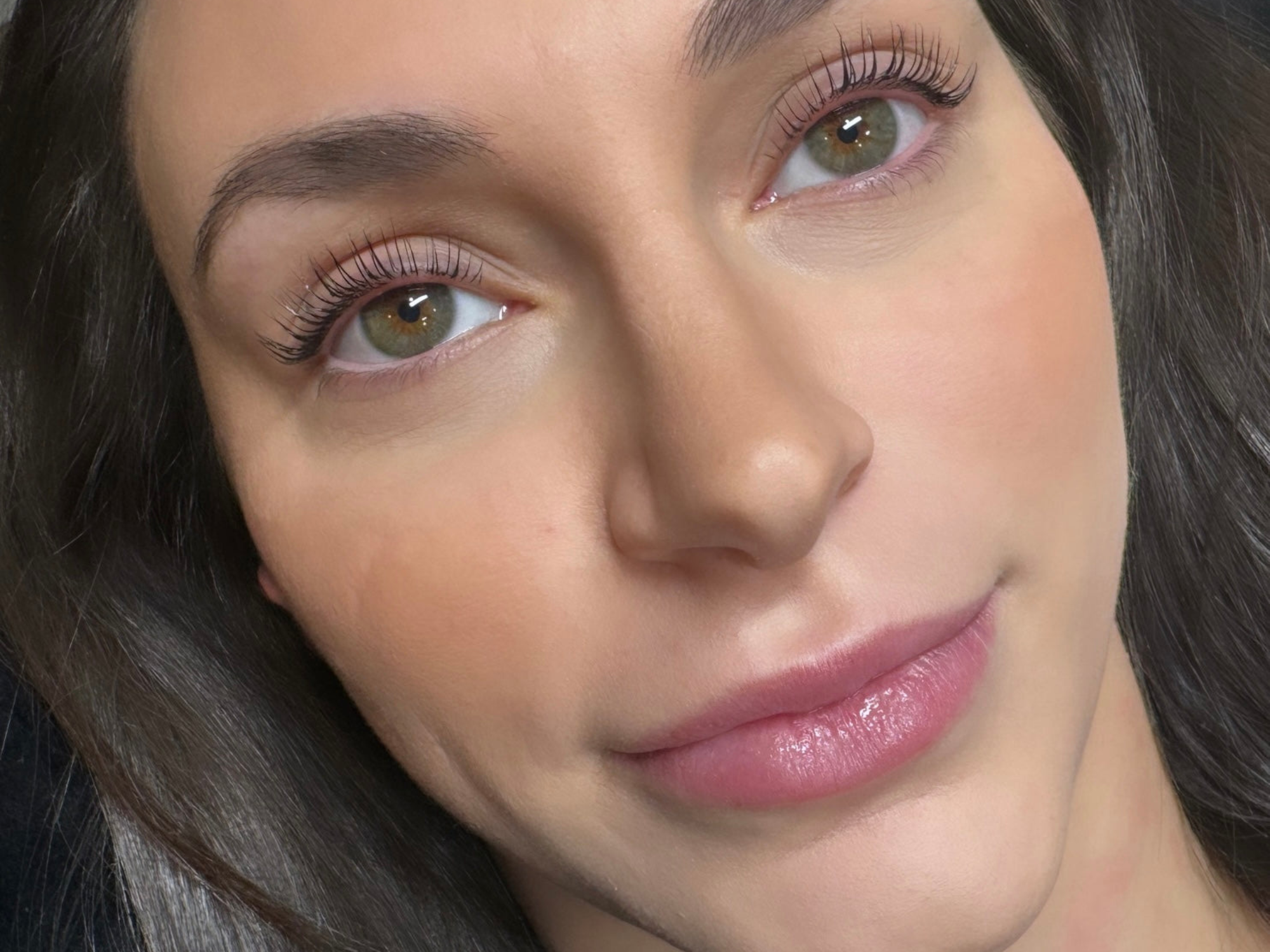 Close-up of a woman’s face showing natural eye look, labeled as before and after using lash lift.